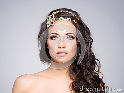 Attractive, curly brunette with a flower golden headband Stock Photo