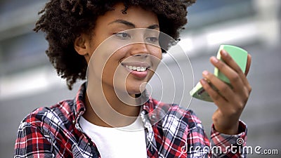 Attractive curly haired student looking in hand mirror, enjoying her appearance Stock Photo