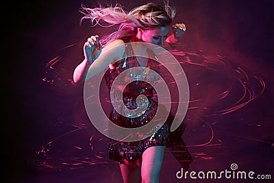 Attractive dancing blonde in the club, neon light, motion effects Stock Photo