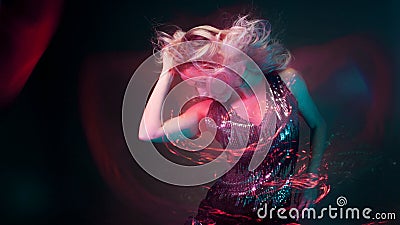 Attractive dancing blonde in the club, neon light, motion effects Stock Photo