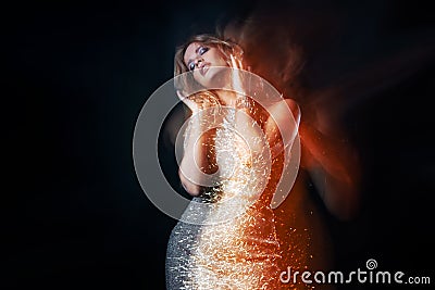 Attractive dancing blonde in the club, shining golden light. Stock Photo