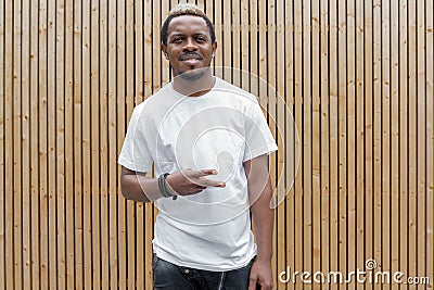 Attractive dark-skinned man in white T-shirt showing victory sign. Stock Photo