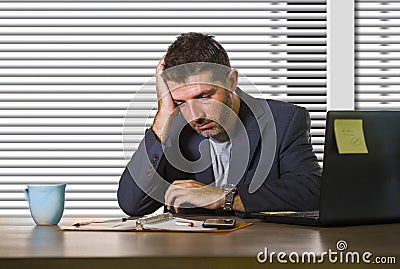 Attractive depressed and frustrated man working at office computer desk desperate and overwhelmed with financial business problem Stock Photo