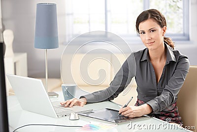 Attractive designer using tablet and laptop Stock Photo