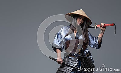 Attractive eastern woman warrior with katana and hat Stock Photo