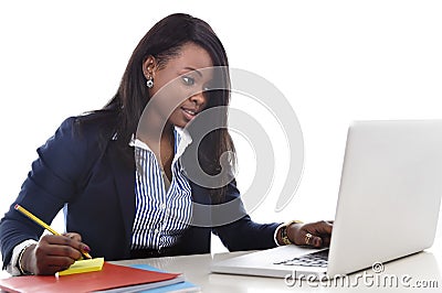 Attractive and efficient black ethnicity woman sitting at office computer laptop desk typing Stock Photo