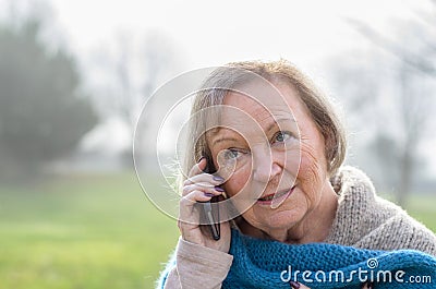Attractive elderly woman talking on her mobile Stock Photo