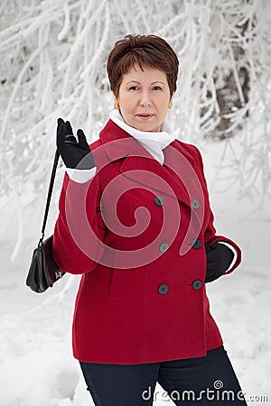 Attractive elderly woman on winter snowy street Stock Photo