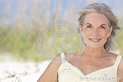 Attractive Elegant Senior Woman Sitting At A Beach Stock Photo
