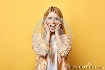 Blonde woman with palms on cheeks, expresses her happiness Stock Photo