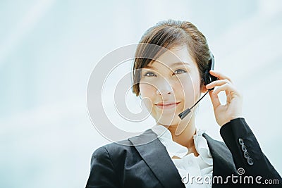 Attractive female Asian businesswoman wearing a headphones with microphone Stock Photo