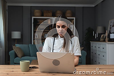 Attractive female doctor make online video call consult patient on laptop. Medical assistant young woman therapist Stock Photo