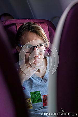 Attractive female passanger watching in-flight entertainment. Stock Photo