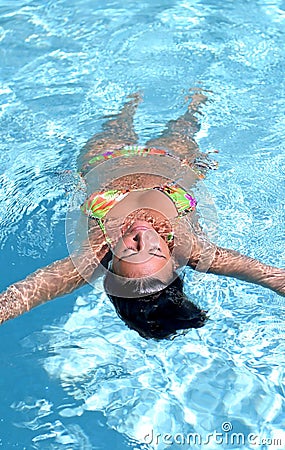 Attractive, fit woman floating in swimming pool Stock Photo