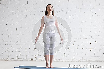 Attractive fit young woman doing Mountain pose in white loft Stock Photo