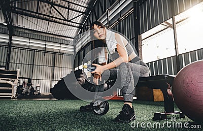 Attractive fitness woman sitting on a chair and resting after workout at fitness centre. Female take a break after hard Stock Photo