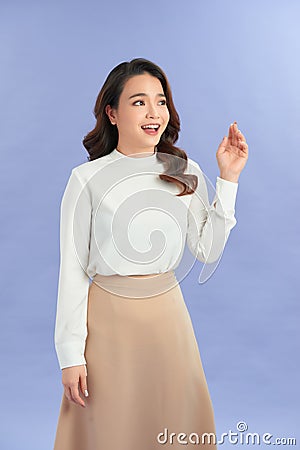 Attractive friendly looking young woman smiling happily, saying Hello, Hi or Bye, waving hand Stock Photo