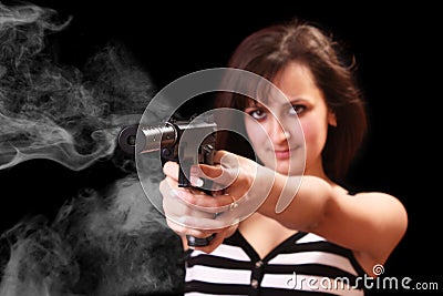 Attractive girl aiming with gun with smoke Stock Photo