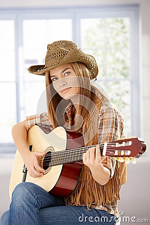 Attractive girl playing guitar in western hat Stock Photo