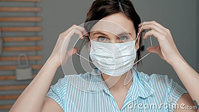 Attractive girl puts on surgical mask on her face. Cold, flu, virus, acute respiratory infections, quarantine, epidemic, irony, Stock Photo