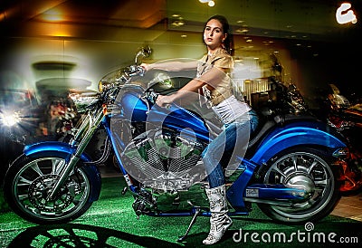 Attractive girl sitting on a blue motorcycle, moto show Stock Photo