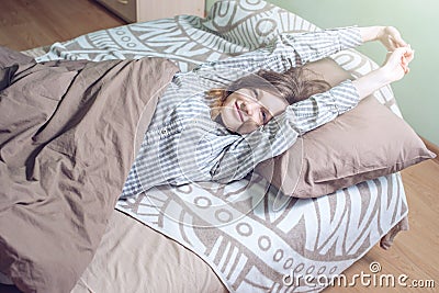 Woman waking up in the morning, lying sleepy in bed Stock Photo