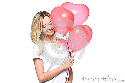 attractive girl in white shirt holding bundle of heart shaped balloons Stock Photo