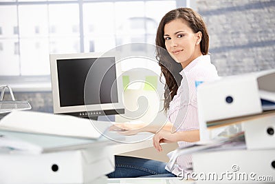 Attractive girl working in bright office smiling Stock Photo