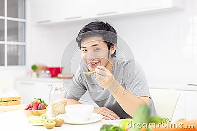 Attractive handsome man eat breakfast or cereal, fruits, milk on Stock Photo