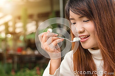 Attractive happy cute young asian woman sitting and eating dessert at outdoors cafe. Food, junk-food, culinary, baking and holiday Stock Photo