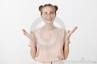 Attractive happy and stylish european woman in trendy glasses and pink t-shirt, raising palms and gesturing joyfully Stock Photo