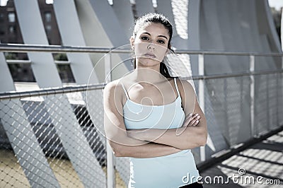Attractive hispanic brunette woman looking cool and defiant after running workout Stock Photo