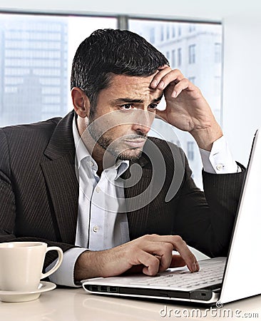 Attractive Hispanic businessman working with computer looking stressed and worried facing work issue Stock Photo