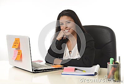 Attractive hispanic businesswoman sitting at office desk working on computer laptop smiling happy Stock Photo