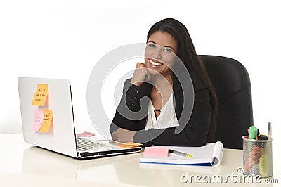 Attractive hispanic businesswoman sitting at office desk working on computer laptop smiling happy Stock Photo