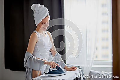 Attractive housewife iron clothes at home Stock Photo