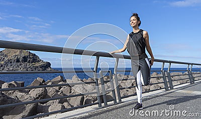 Attractive jogger woman warming the legs before go to running. Athlete runner standing with balance stretch her fit body with Stock Photo