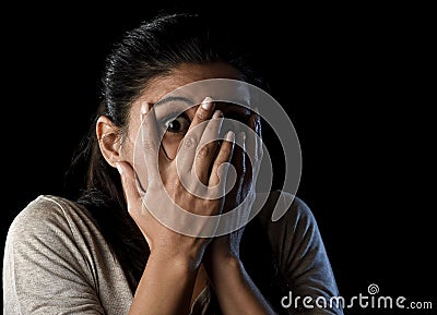 Attractive Latin woman scared terrorized and horrified covering her eyes Stock Photo