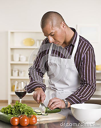 Attractive male cutting salad Stock Photo