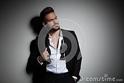Attractive man in black tuxedo adjusting his suit Stock Photo