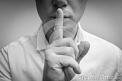 Attractive man with finger on lips making silence gesture Stock Photo