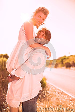 Attractive man lifting up his girlfriend smiling at camera Stock Photo