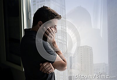 Attractive man looking through window suffering emotional crisis and depression Stock Photo