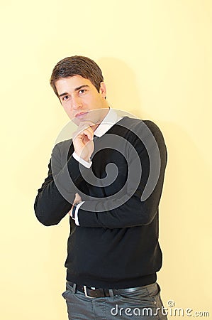 Attractive man standing and thinking against wall Stock Photo