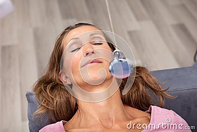 Woman Being Hypnotized While Lying On Sofa Stock Photo