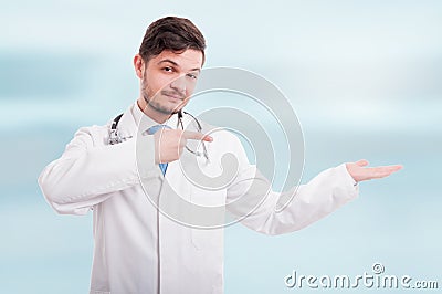 Attractive medic pointing to his empty palm hand Stock Photo