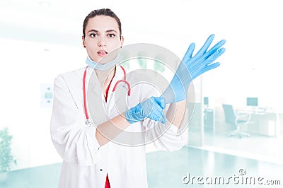 Attractive medic putting gloves on Stock Photo