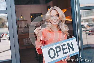 attractive middle aged small business owner holding sign open and smiling Stock Photo