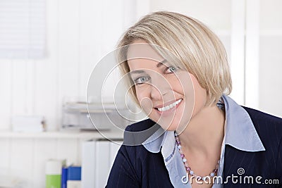 Attractive middle aged woman in business outfit sitting in her o Stock Photo