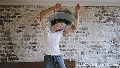 Attractive mixed race young joyful woman have fun dancing near bed at home Stock Photo